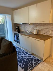 Una cocina con gabinetes blancos y encimera. en FeWo Krems "Unnerkant" Steinhude, en Wunstorf