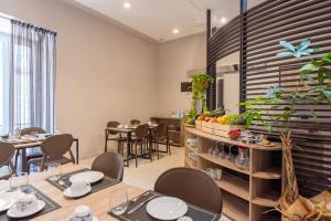 restauracja ze stołami i krzesłami w pokoju w obiekcie Neapolis Lifestyle w mieście Neapol