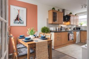 a kitchen with a wooden table and a dining room at Cheshire Retreat, close to Tatton Park in Knutsford