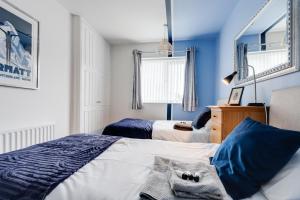 a bedroom with two beds and blue walls at Cheshire Retreat, close to Tatton Park in Knutsford +18 photos