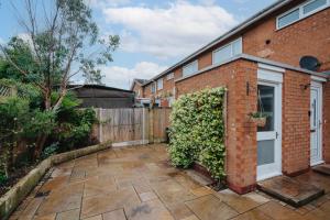 a brick building with a door and a hedge at Cheshire Retreat, close to Tatton Park in Knutsford