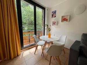 ein Esszimmer mit Tisch und Stühlen und einem Fenster in der Unterkunft Apartamento junto a pistas en Canillo 2-8 HUT-7852 in Canillo