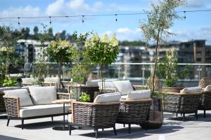 a row of wicker chairs and tables on a roof at Quality Hotel Tønsberg in Tønsberg