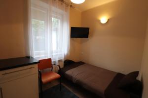 a small bedroom with a bed and a window at Gorce apartamenty i pokoje in Rabka-Zdrój
