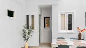ein weißes Esszimmer mit einem weißen Tisch und Stühlen in der Unterkunft Beachhouse Gran Tarajal 3BR in Gran Tarajal + 9 Fotos