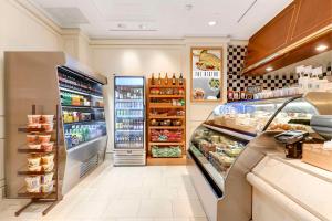 a grocery store aisle with a refrigerator and food at Hilton Los Angeles Airport in Los Angeles