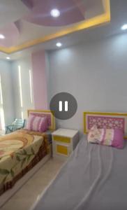 a bedroom with a bed and a nightstand and a bed sidx sidx sidx sidx at العبور in Cairo