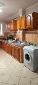 a kitchen with a washing machine on a counter at Grand Appt près de la mer in Hajreien