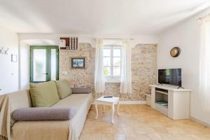 a living room with a couch and a tv at Pinta Apartments in Lumbarda