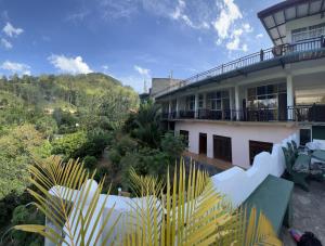 a building with a lot of plants in front of it at Viyanga Homestay in Ella