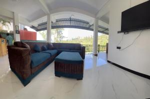 a living room with a couch and a flat screen tv at Viyanga Homestay in Ella