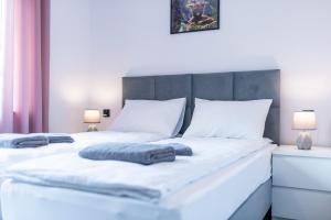 a bedroom with a white bed with two pillows on it at Przystanek Karkonosz in Szklarska Poręba