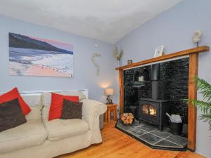 un salon avec un canapé et une cheminée dans l'établissement Stone's Throw Cottage, à Launceston