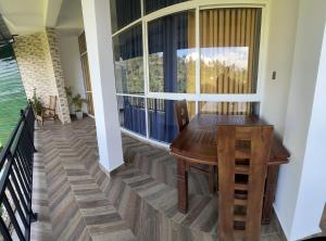 a table and chairs on a porch with a window at Viyanga Homestay in Ella