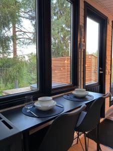 a dining room table with two bowls and plates on it at The Saunacabin Enchanted Lapland in Rovaniemi +20 photos