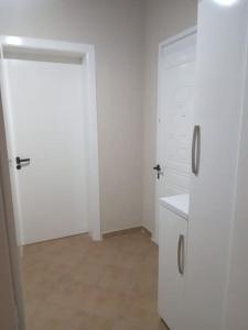 een keuken met witte kasten en een koelkast bij The Little Oasis Villa in Shkodër