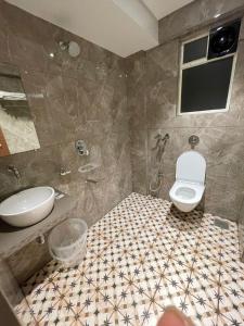 a bathroom with a toilet and a sink at Hotel The West Coast in Vasai