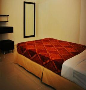 1 dormitorio con cama roja y espejo en Old Budget Hotel en George Town