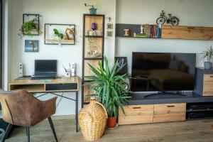 a living room with a desk and a television at Apartman Fjaka in Petrcane