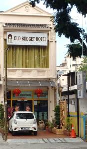 a white car parked in front of an old budget hotel at Old Budget Hotel in George Town
