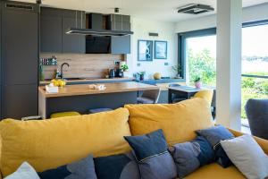 a living room with a couch and a kitchen at Apartman Fjaka in Petrcane