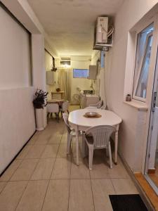 a small white table and chairs in a room at Kostic Apartments in Buljarica