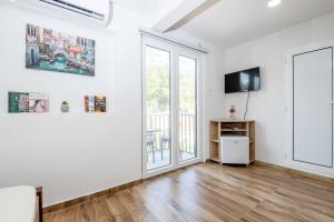 an empty living room with white walls and a sliding glass door at Sumice Inn in Petrovac na Moru
