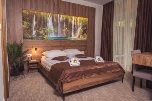 a bedroom with a bed with a painting on the wall at Hotel Tazz - River Front Oasis Collection in Bihać