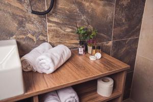 a bathroom with a wooden table with towels on it at Hotel Tazz - River Front Oasis Collection in Bihać +92 photos