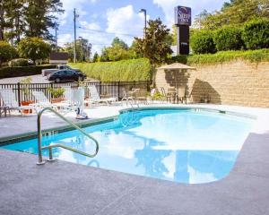a large swimming pool with chairs and a building at Sleep Inn & Suites Near Columbus - State University Area in Columbus
