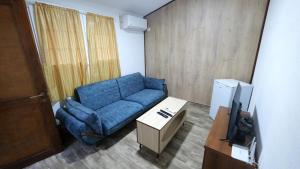 a living room with a blue couch and a tv at Sirena Agroturizem in (( Stan i Ri ))
