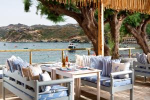 a table and chairs on a patio with a view of the water at Out Of The Blue Resort & Spa in Agia Pelagia