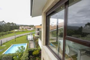 ventana de una casa con vistas a la piscina en Apartamento en Valoria con piscina, en Valoria