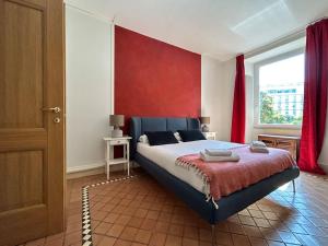 a bedroom with a large bed with a red wall at Elegant 3 bedrooms apartment Colosseum - San Giovanni in Rome