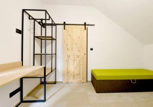 a room with a green bench and a wooden door at Folwark Matecznik - Spichlerz in Sedzinko
