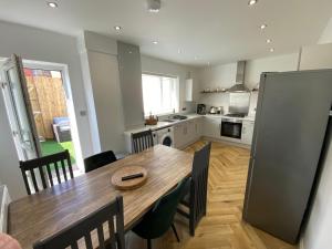 a kitchen and dining room with a wooden table and chairs at Marine Cottage 2 - With Private Hot Tub in Newbiggin-by-the-Sea