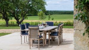 Una mesa y sillas de madera en un patio. en Otmoor House, en Beckley