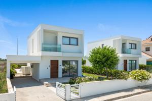 una casa blanca con una valla blanca en Serenity Waves Villa 16, en Lárnaca