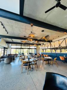 ein Esszimmer mit Tischen und Stühlen und Fenstern in der Unterkunft 13 Elizabeth Place - Beautiful 2 bedroom unit next to Kyalami Racetrack with free WiFi - swimming pool gym and restaurant - Perfect for a small family in Midrand Waterfall in Midrand