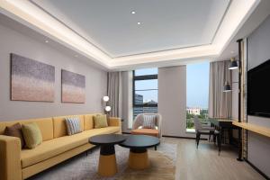 a living room with a couch and a tv at Hilton Garden Inn Beijing Huaxiang Tiantan Hospital in Beijing