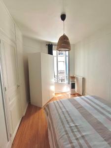 a bedroom with a bed and a large window at Charmant T2 cosy et lumineux proche métro in Pantin
