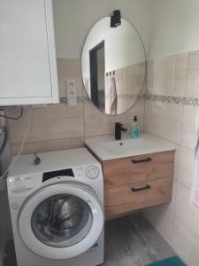 a bathroom with a washing machine and a mirror at Ubytování Na Slunku 2 in Velká Kraš