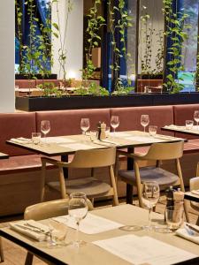a row of tables in a restaurant with wine glasses at Vibe Hotel Melbourne Docklands in Melbourne