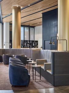 a lobby with chairs and tables and a bar at Vibe Hotel Melbourne Docklands in Melbourne