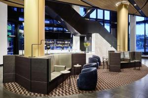 a lobby with a bar with chairs and a staircase at Vibe Hotel Melbourne Docklands in Melbourne