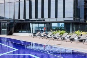 a row of lounge chairs sitting next to a building at Vibe Hotel Melbourne Docklands in Melbourne