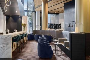 a restaurant with blue chairs and a bar at Vibe Hotel Melbourne Docklands in Melbourne