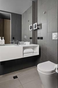 a bathroom with a tub and a toilet and a sink at Vibe Hotel Melbourne Docklands in Melbourne