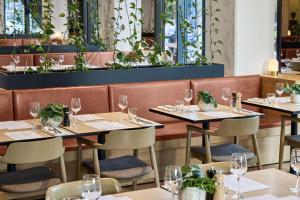 a restaurant with tables and chairs with wine glasses at Vibe Hotel Melbourne Docklands in Melbourne