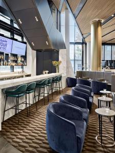 a restaurant with blue chairs and a bar at Vibe Hotel Melbourne Docklands in Melbourne